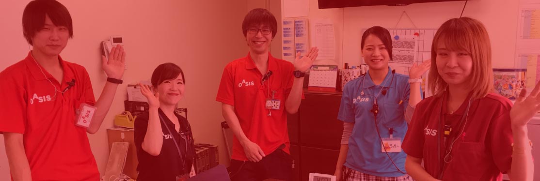 事務所内で手を挙げ、こちらに挨拶をするスタッフたち